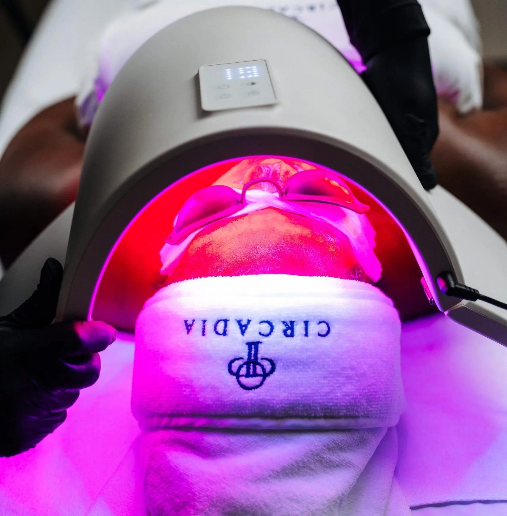 Kundin unter der LED-Lichttherapie im Studio von Büsra Boz in Schrobenhausen, Circadia Haarband, magentafarbenes Licht