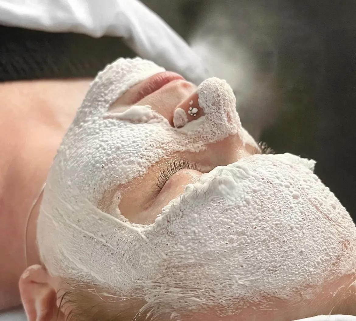 Weiße Oxygen RX Maske auf dem Gesicht einer Kundin während der Behandlung